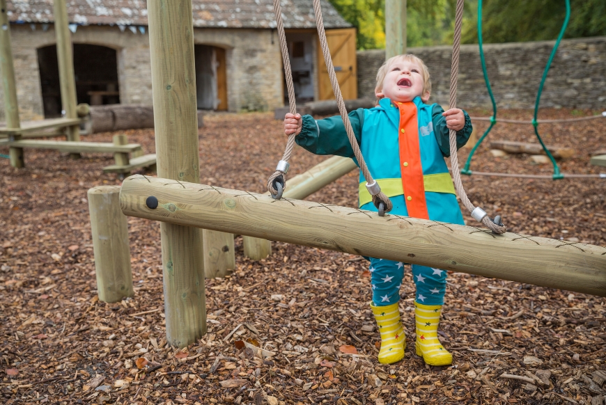 A small child playing on some outdoor play equiptment